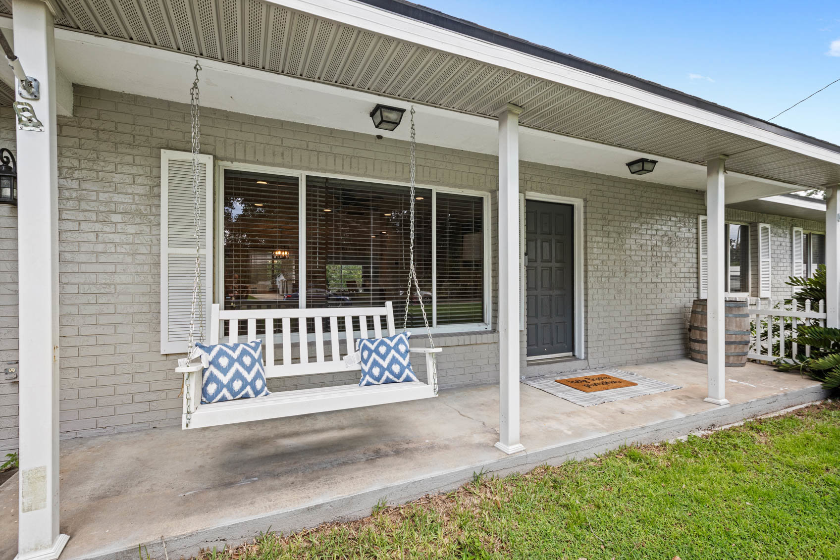 front porch with blue door and white bench swing